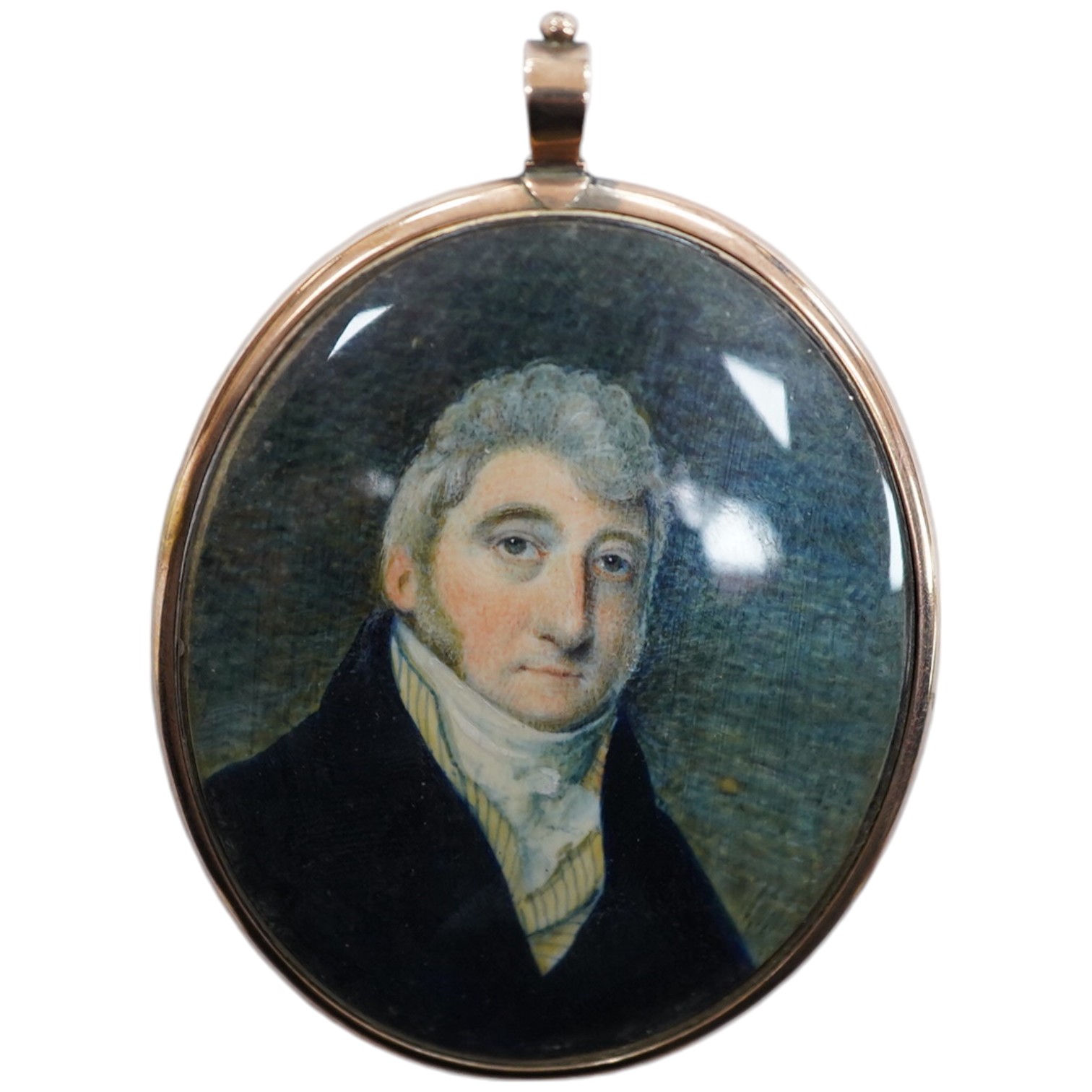 A George III oval portrait miniature on ivory, portrait of a gentleman, lock of hair verso, 6.5cm high, housed in a yellow metal case. Condition - good. CITES Submission reference, 6LF46WVD